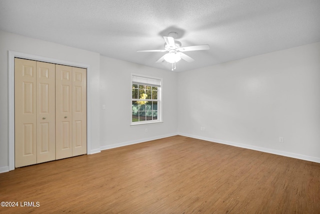 unfurnished bedroom featuring ceiling fan, a textured ceiling, a closet, and light hardwood / wood-style flooring