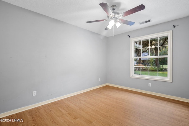 unfurnished room featuring ceiling fan, a textured ceiling, and light wood-type flooring