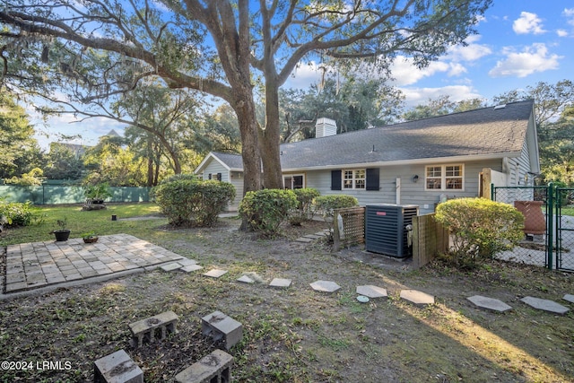 rear view of house with central AC unit and a patio area