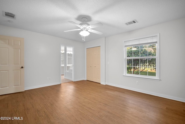 unfurnished room featuring ceiling fan, light hardwood / wood-style flooring, and a textured ceiling