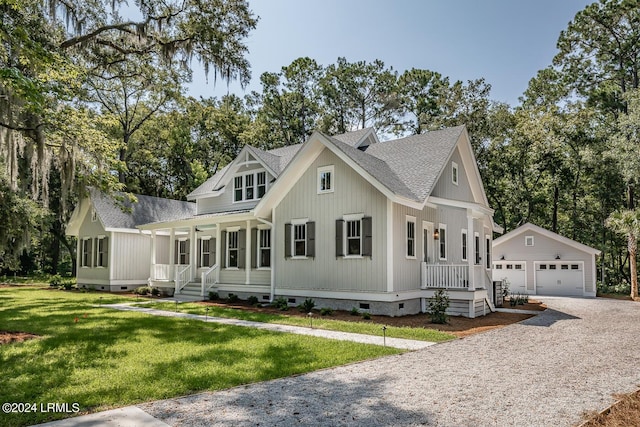 view of front of property with an outbuilding, a garage, a front yard, and covered porch