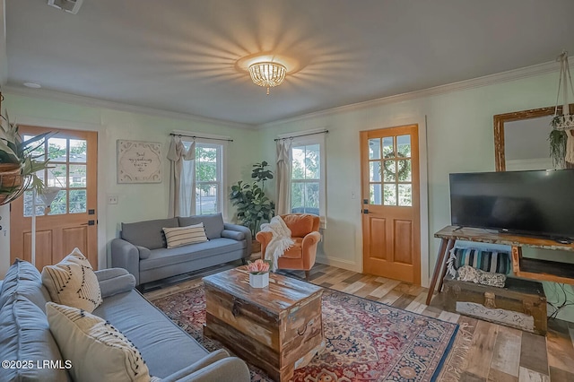 living area with baseboards, wood finished floors, and crown molding