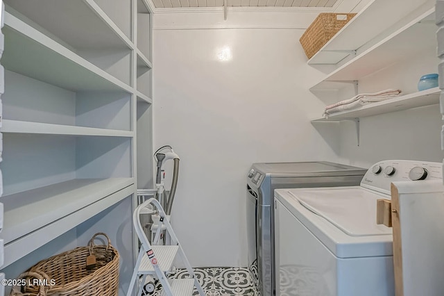 clothes washing area featuring washing machine and clothes dryer, laundry area, and tile patterned floors