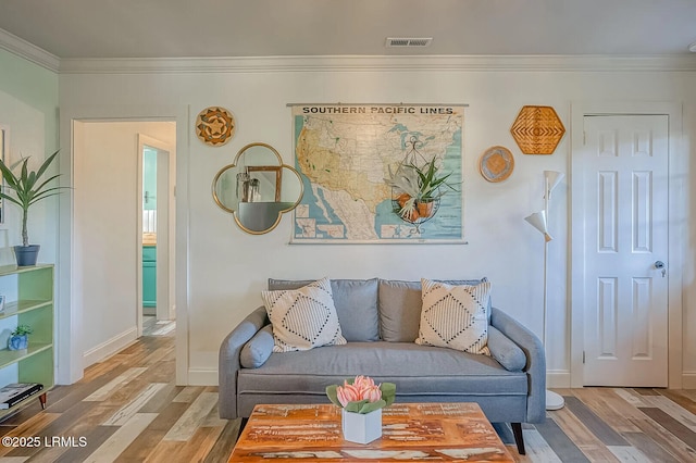 living room with visible vents, ornamental molding, baseboards, and wood finished floors