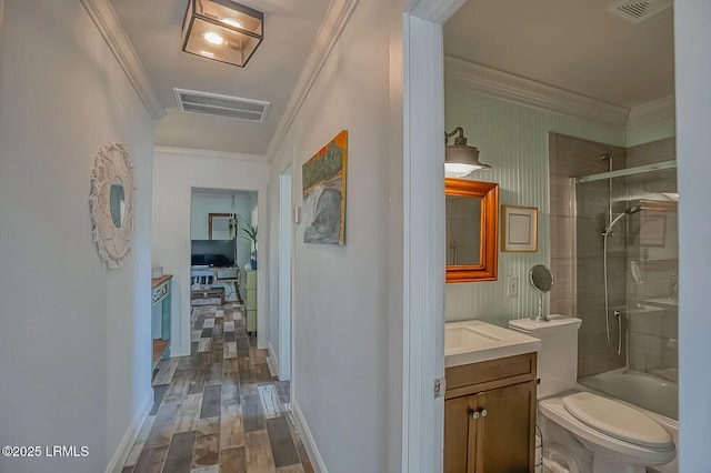 interior space with dark wood-style floors, visible vents, crown molding, and baseboards