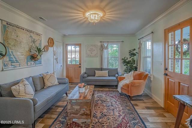 living area featuring visible vents, baseboards, wood finished floors, and crown molding