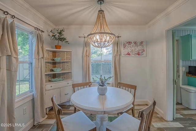 dining area with crown molding, a notable chandelier, a healthy amount of sunlight, and baseboards