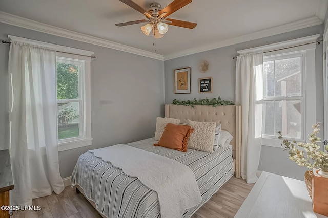 bedroom featuring baseboards, wood finished floors, a ceiling fan, and ornamental molding