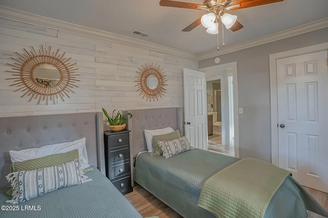 bedroom with visible vents, wood finished floors, ceiling fan, and ornamental molding