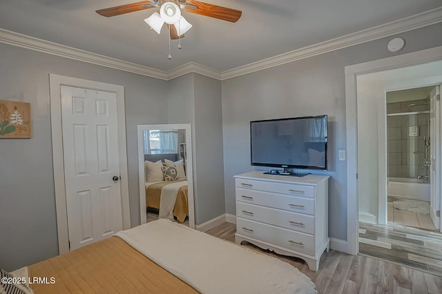 bedroom with baseboards, ensuite bathroom, crown molding, and light wood finished floors