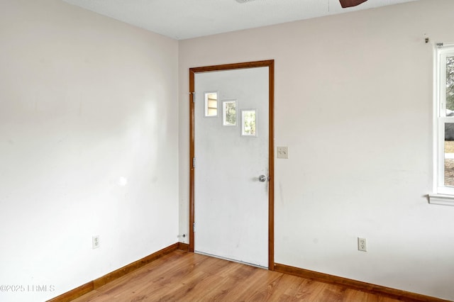 entryway featuring light wood-style flooring, a ceiling fan, and baseboards