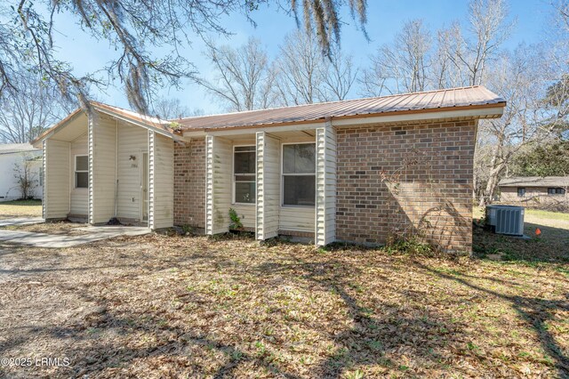 1986 Pulaski Dr, Beaufort, SC 29906 - view of home's exterior featuring metal roof, brick siding, and cooling unit