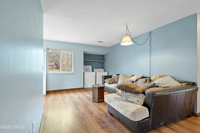 1986 Pulaski Dr, Beaufort, SC 29906 - living area with a textured ceiling, wood finished floors, baseboards, and washer and clothes dryer