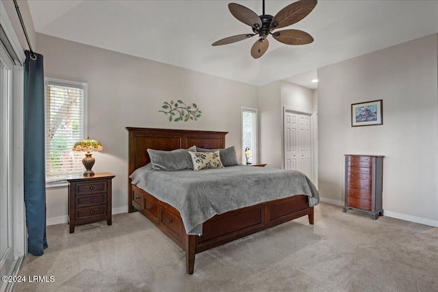 bedroom featuring ceiling fan, light colored carpet, and a closet