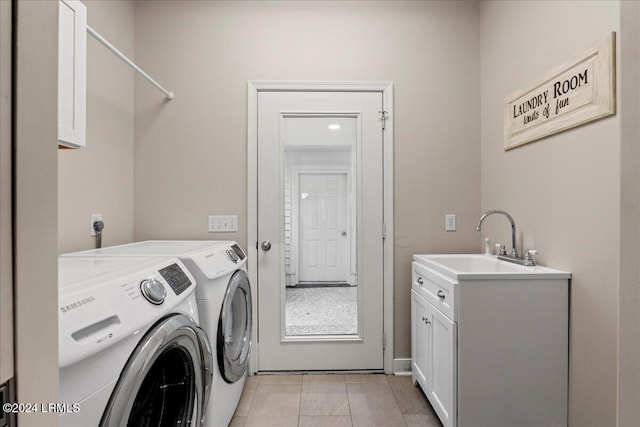 washroom featuring cabinets, washing machine and clothes dryer, light tile patterned flooring, and sink