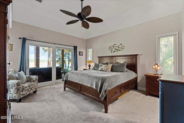 carpeted bedroom featuring ceiling fan, lofted ceiling, multiple windows, and access to outside