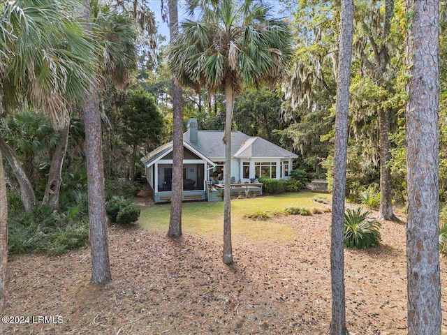 view of front of property featuring a sunroom and a front lawn