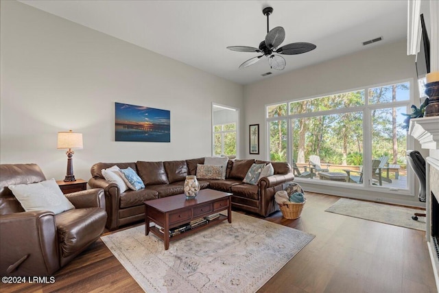 living room with ceiling fan, dark hardwood / wood-style floors, and a fireplace