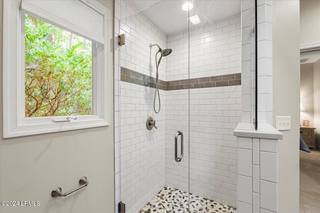 bathroom with a shower with door and a wealth of natural light