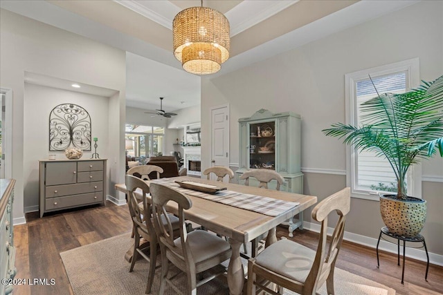 dining space featuring ornamental molding, ceiling fan with notable chandelier, dark wood-type flooring, and a wealth of natural light