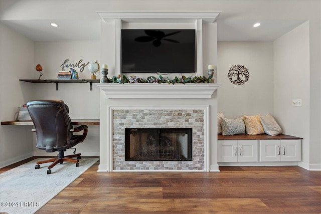 living room featuring a tile fireplace and dark wood-type flooring