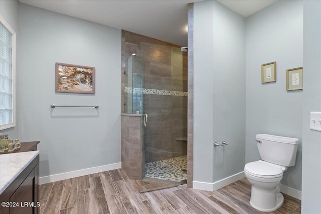 bathroom featuring vanity, toilet, a shower with door, and hardwood / wood-style floors