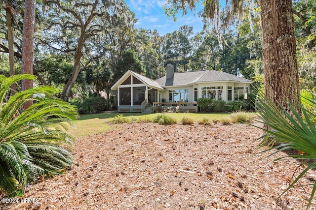 back of property featuring a lawn and a sunroom