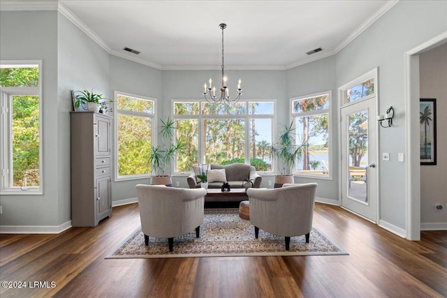 sitting room with crown molding, a notable chandelier, dark hardwood / wood-style floors, and a wealth of natural light