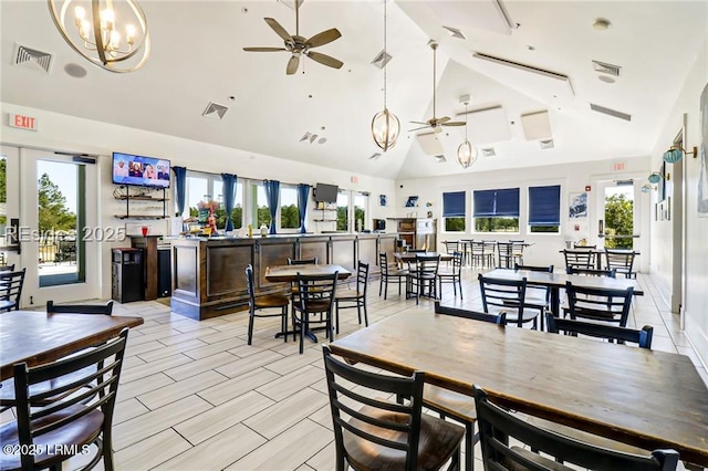 dining area featuring ceiling fan with notable chandelier, vaulted ceiling, french doors, and plenty of natural light