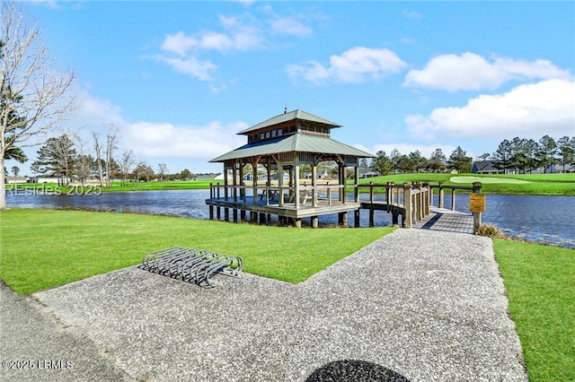 view of dock with a gazebo, a water view, and a yard