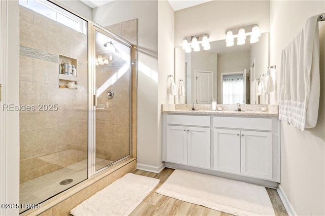 bathroom with a shower with door, vanity, and hardwood / wood-style floors
