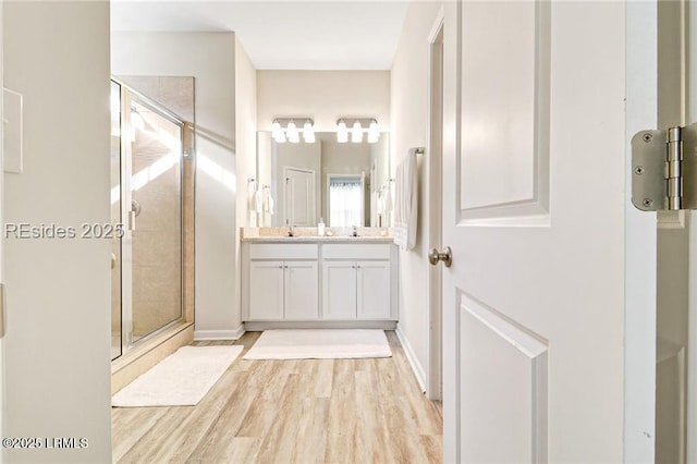 bathroom featuring walk in shower, vanity, and hardwood / wood-style floors