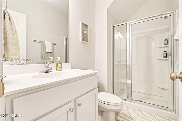 bathroom featuring lofted ceiling, vanity, toilet, and a shower with shower door