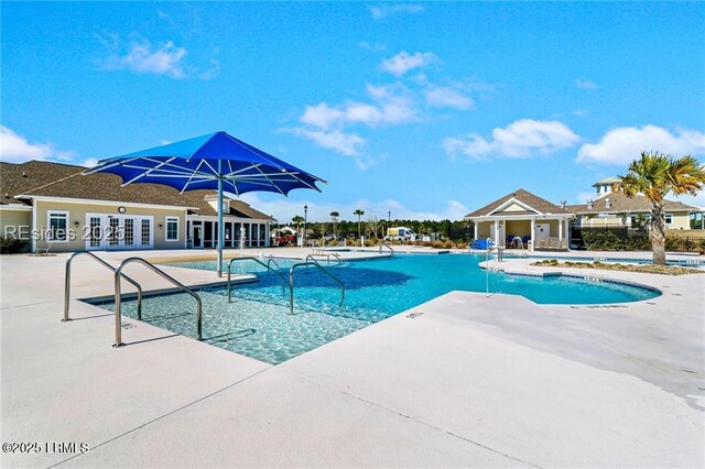view of pool with french doors and a patio area