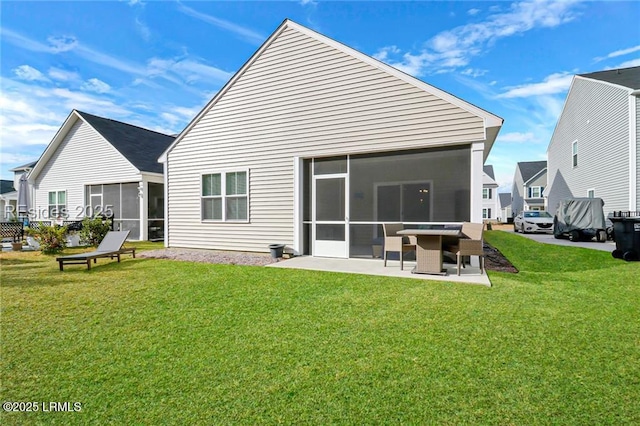rear view of property with a lawn, a sunroom, and a patio area