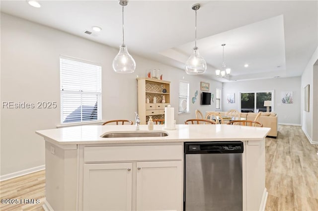 kitchen with white cabinetry, dishwasher, a kitchen island with sink, and a raised ceiling