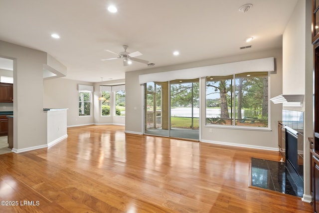7 Fenwick Dr, Bluffton, SC 29909 - unfurnished living room featuring a fireplace, baseboards, ceiling fan, light wood-type flooring, and recessed lighting