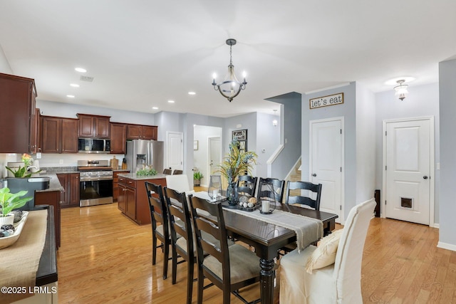 dining room featuring visible vents, baseboards, light wood-style flooring, an inviting chandelier, and recessed lighting