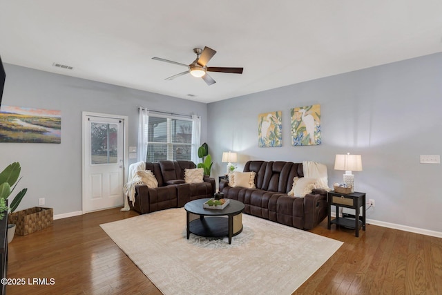 living room featuring ceiling fan, wood finished floors, visible vents, and baseboards