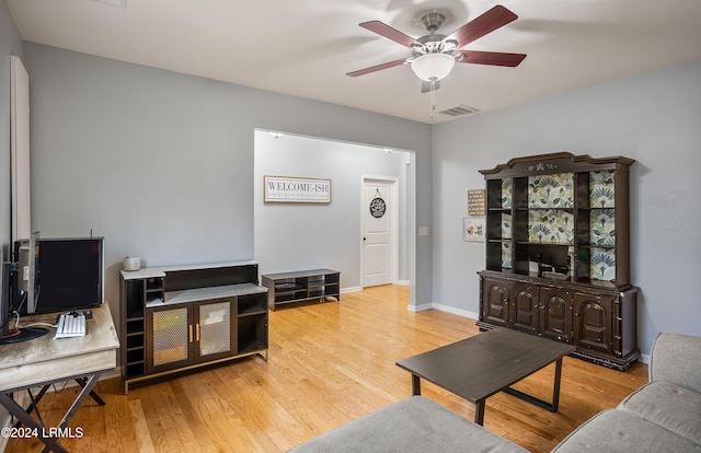 living room featuring hardwood / wood-style floors and ceiling fan