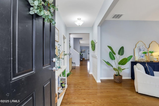 entrance foyer featuring stairway, visible vents, light wood-style flooring, and baseboards