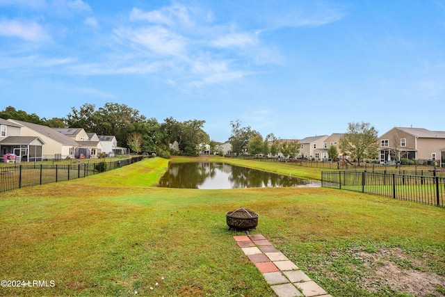 view of yard with a water view and an outdoor fire pit