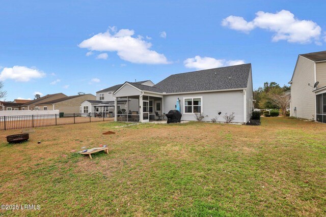 back of house featuring a sunroom, a patio area, and a lawn