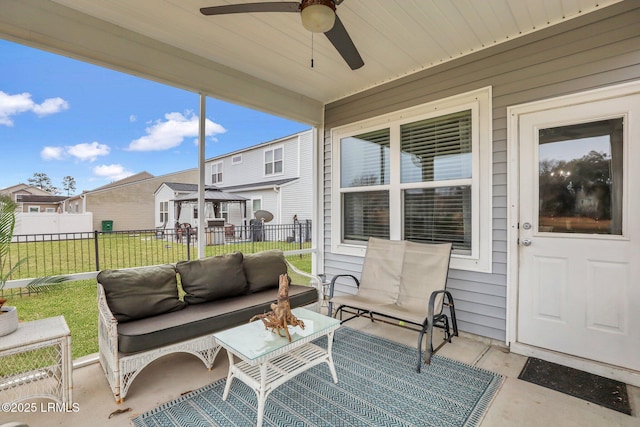 sunroom / solarium with a residential view and a ceiling fan