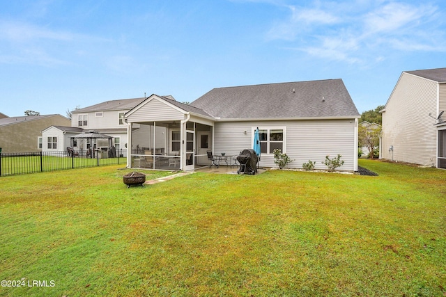 back of house with a yard, a gazebo, a sunroom, and an outdoor fire pit