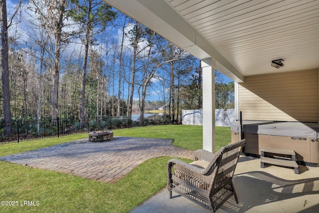 view of patio featuring a hot tub, a fire pit, a fenced backyard, and a water view