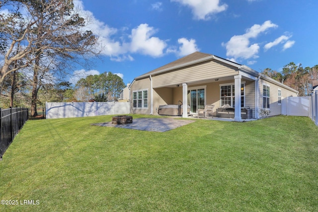 rear view of house with a lawn, a patio, an outdoor fire pit, and a fenced backyard