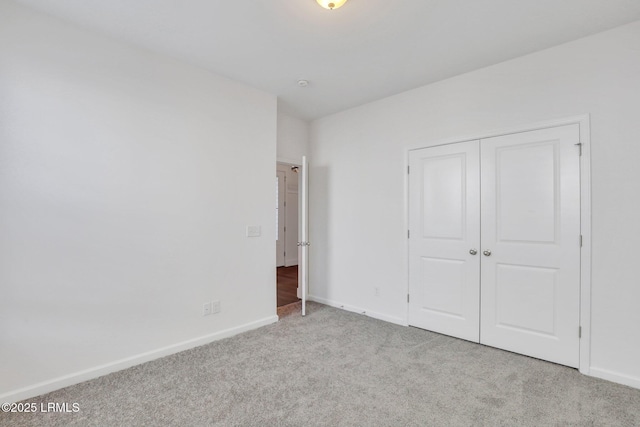 unfurnished bedroom with a closet, baseboards, and carpet