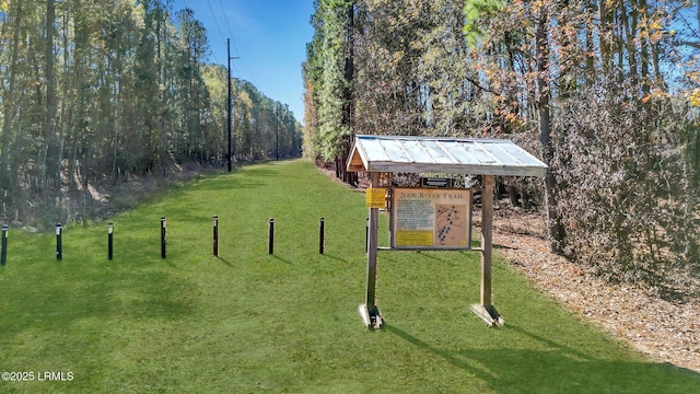 view of property's community with a yard and a forest view