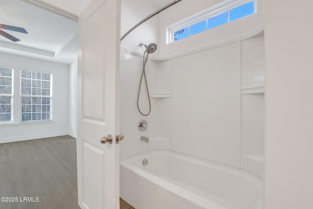 full bath featuring baseboards, bathing tub / shower combination, ceiling fan, and wood finished floors